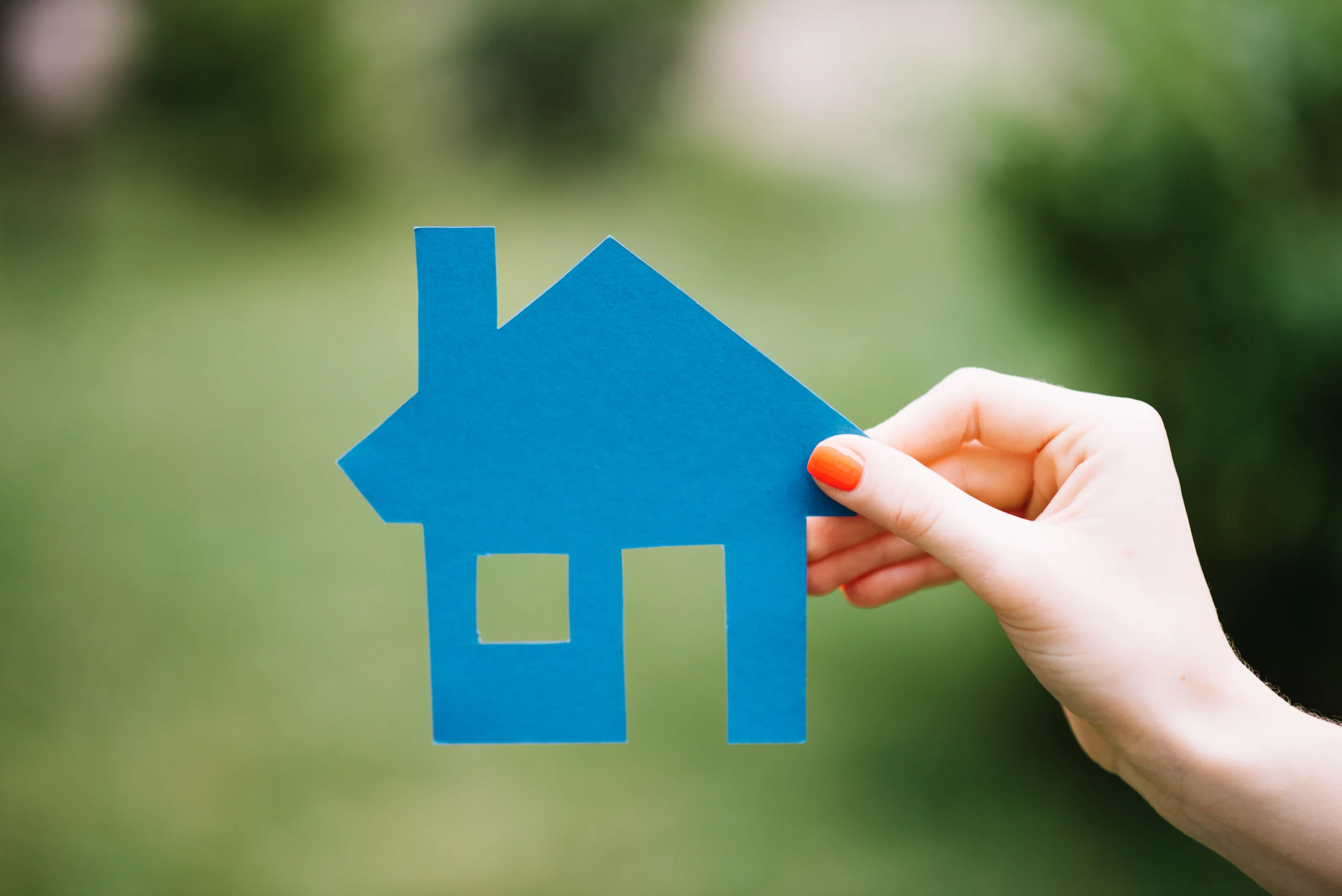 crop-woman-holding-blue-house-scaled.webp